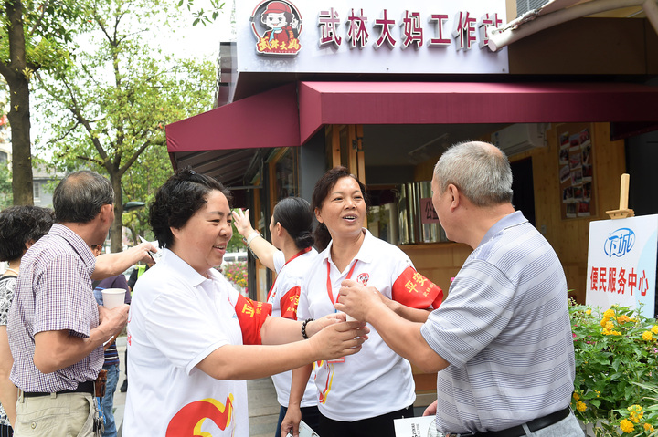 武林大妈党员志愿者在微笑亭为游客指路并送上凉茶.jpg