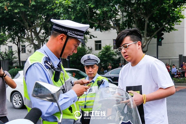 交警孙坚在早上8点53分将孩子送到了学军中学考点门口.jpg