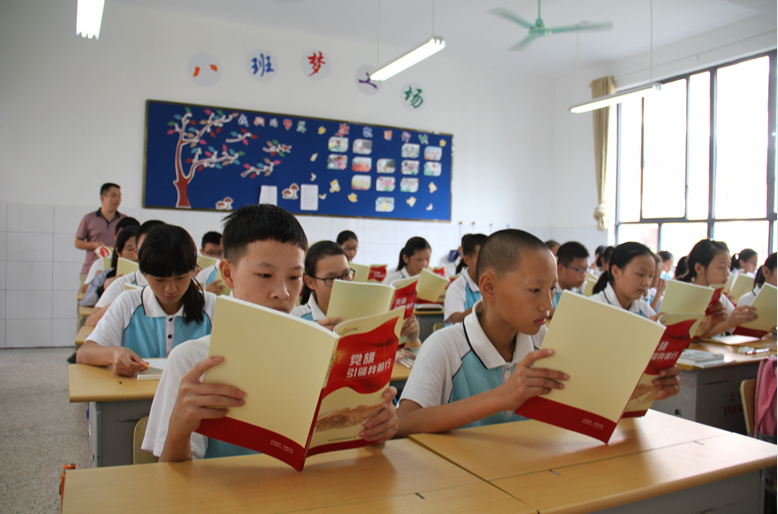 学生们集体学习《党旗引领我前行》一书。.png